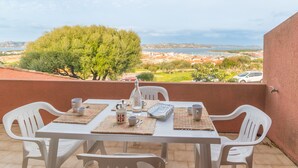 A table set for two with a view of a coastal town.