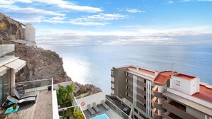 Un hotel con piscina, lettini e vista sul mare.
