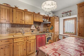 Una cucina con mobili in legno, un fornello e una finestra vista.