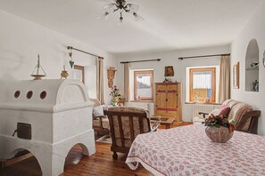 Una camera tradizionale con un camino in pietra, mobili in legno e un letto con copriletto floreale.