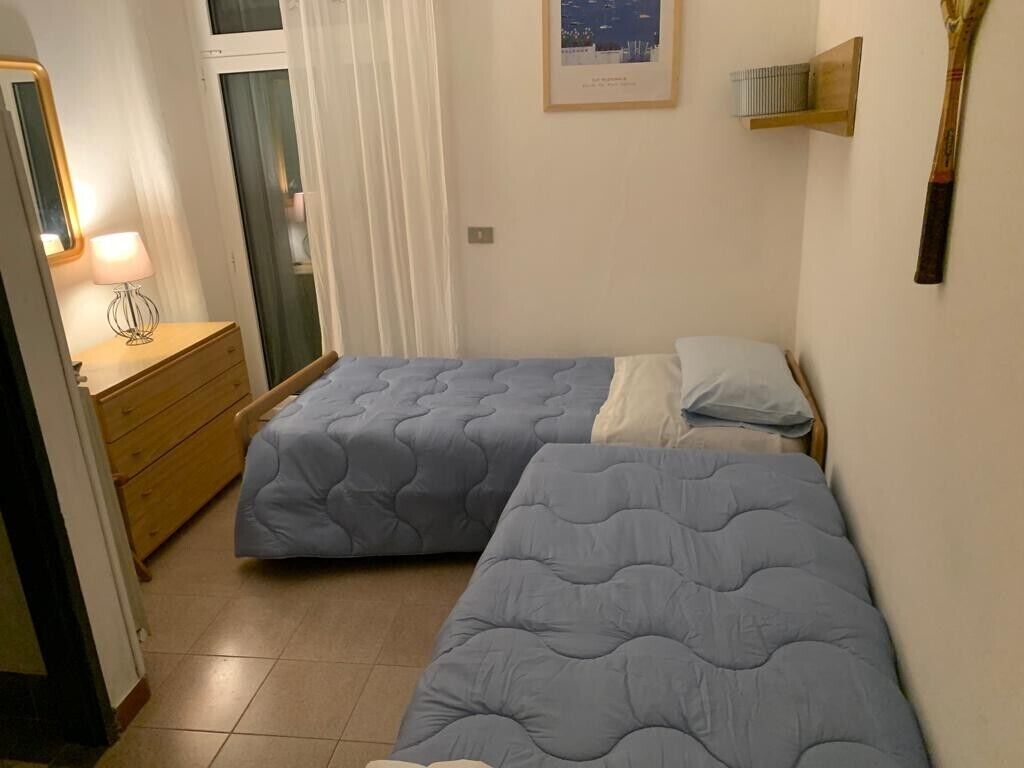 Ein Schlafzimmer mit zwei Betten, einem Holzkleiderschrank, einem Spiegel und einem Stadtlandschaftsposter an der Wand.