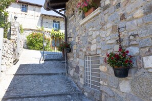 A stone staircase leading to a building with a metal gate, potted plants, and a window. - Apartment 'Casa Rita App 4 A' with Terrace, Garden and Shared Wi-Fi (Tremosine)