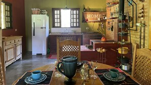 A cozy kitchen with a refrigerator, stove, and a 'HOME' sign on the wall.