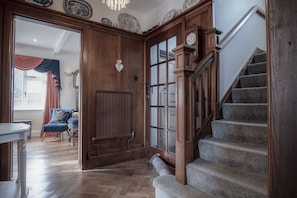 Classic staircase leads to an upper level, featuring a handrail and wooden banister.