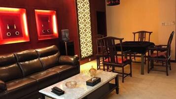 A modern living room with a leather sofa, a coffee table, and wooden chairs.