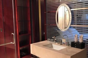 A modern bathroom with a large mirror, a sink, and a shower area. - Heizhugou Midou Hotel (Ebian)