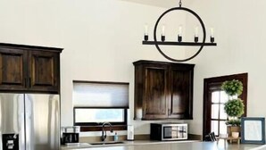 Een moderne keuken met een centraal eiland, roestvrijstalen apparatuur en donkerhouten kastjes.