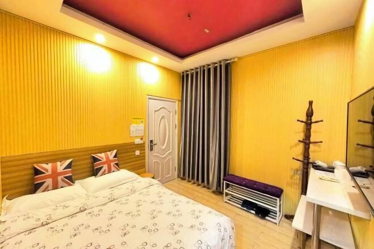 Une chambre d’hôtel avec un lit, un bureau, un miroir et une porte.