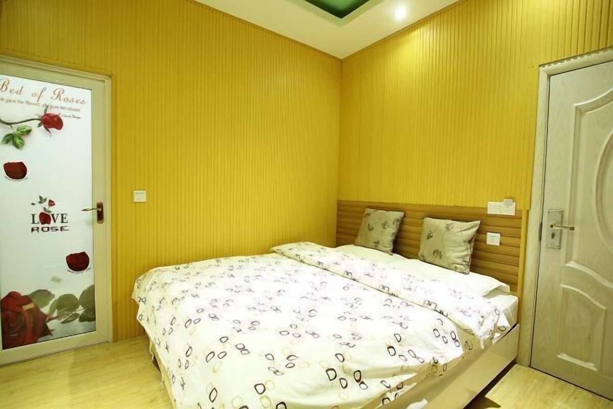 Un dormitori amb llit, una porta decorada amb roses i una paret amb un disseny floral.
