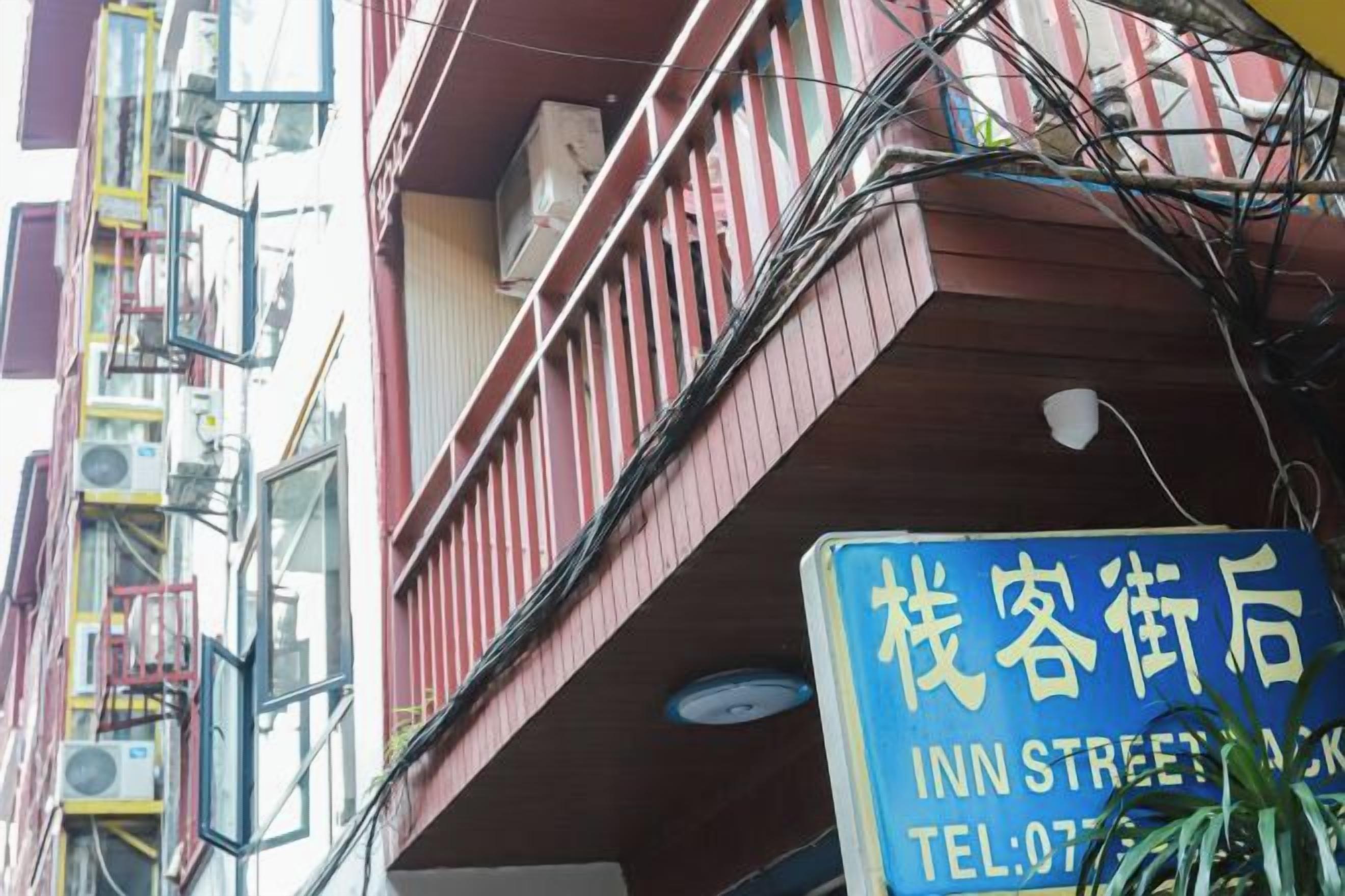 Une enseigne d’hôtel avec un balcon et plusieurs unités de climatisation.