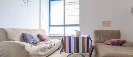A living room with two sofas, a small table, and a window.