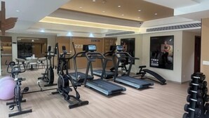 A modern gym with treadmills, elliptical machines, and free weights. - Yonghaoyuan Hotel (Luoding)