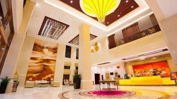 A spacious lobby with a reception desk, seating area, and a large mural on the wall. - Yonghaoyuan Hotel (Luoding)