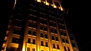 A high-rise building with multiple floors, illuminated by warm lighting. - Yonghaoyuan Hotel (Luoding)