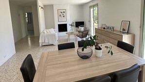A modern dining area with a wooden table, black chairs, and a woven pendant light. - Pleasant house in a quiet area, swimming pool, air conditioning, WIFI, max 12 pers. (Uchaux)