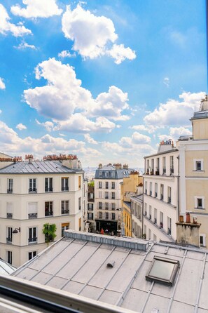 A cityscape with multiple buildings, a clear sky, and a few clouds.