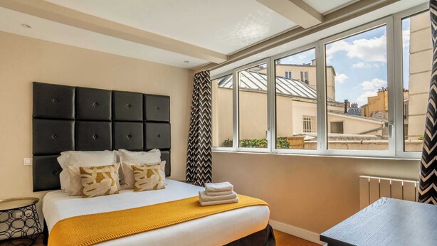 Une chambre à coucher avec un lit, une fenêtre, un radiateur et une petite table.