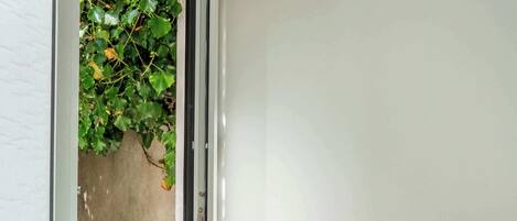A bathroom with a white sink, a window with a view of greenery, and a towel rack.