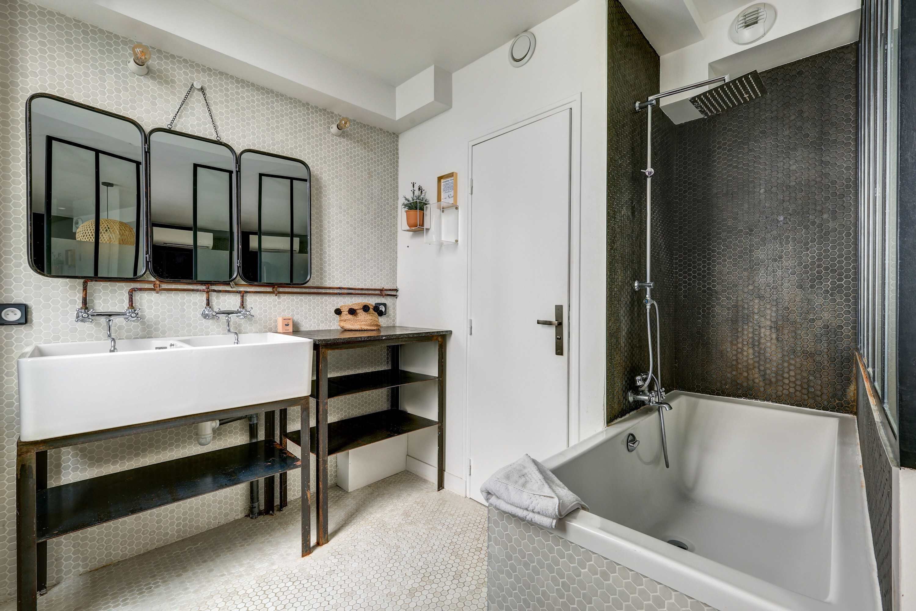 A bathroom with a large bathtub, a double sink vanity, and a shower area.