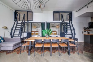 A modern interior with a dining area, staircase, and kitchen. - Stylish and sunny 7BD with garden for 17 guests! (Paris)