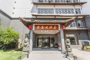 A traditional building with a tiled roof, a signboard, and two stone lion statues at the entrance. - Nanxijiang Jintai Hotel (Yongjia)