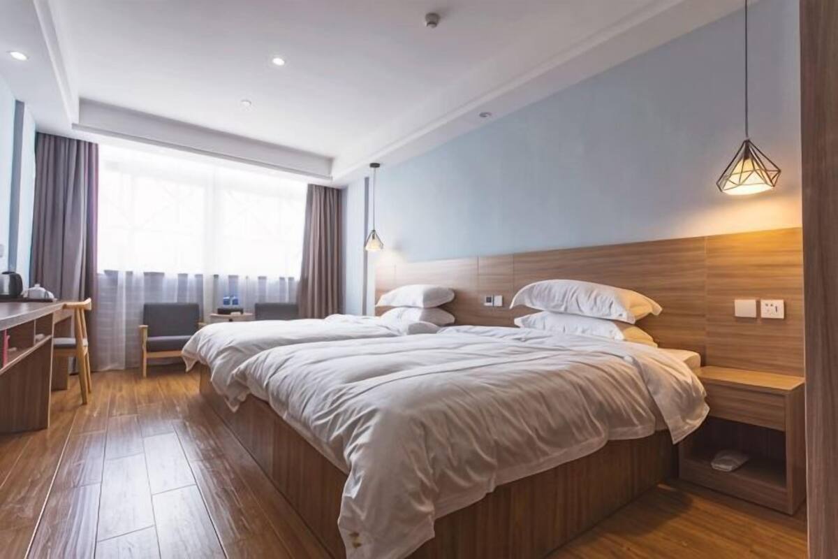 Une chambre d’hôtel avec un grand lit, un bureau et une chaise.