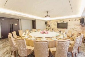 A conference room with a round table, chairs, and a television on the wall. - Nanxijiang Jintai Hotel (Yongjia)