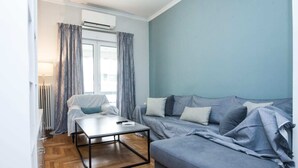 A compact living space with a grey sofa, a small table, and a radiator.