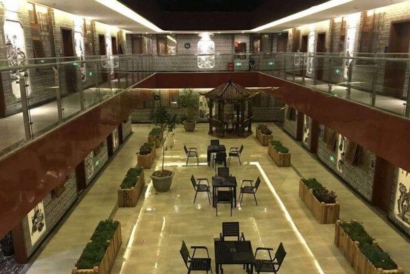 A multi-level atrium with seating areas, a central gazebo, and a glass railing.