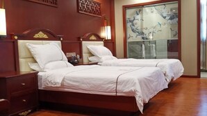 A hotel room with two beds, wooden headboards, a nightstand, and a decorative wall panel. - Guihou Hotel (Kunming)