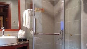 A bathroom with a sink, mirror, towel rack, and a glass shower enclosure. - Guihou Hotel (Kunming)