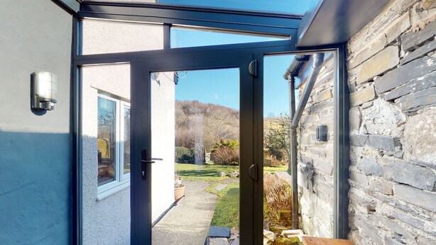 A modern room with a glass door leading to a garden.