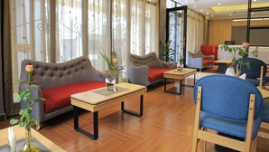 Un vestíbulo de hotel con sofás, sillas y una mesa.