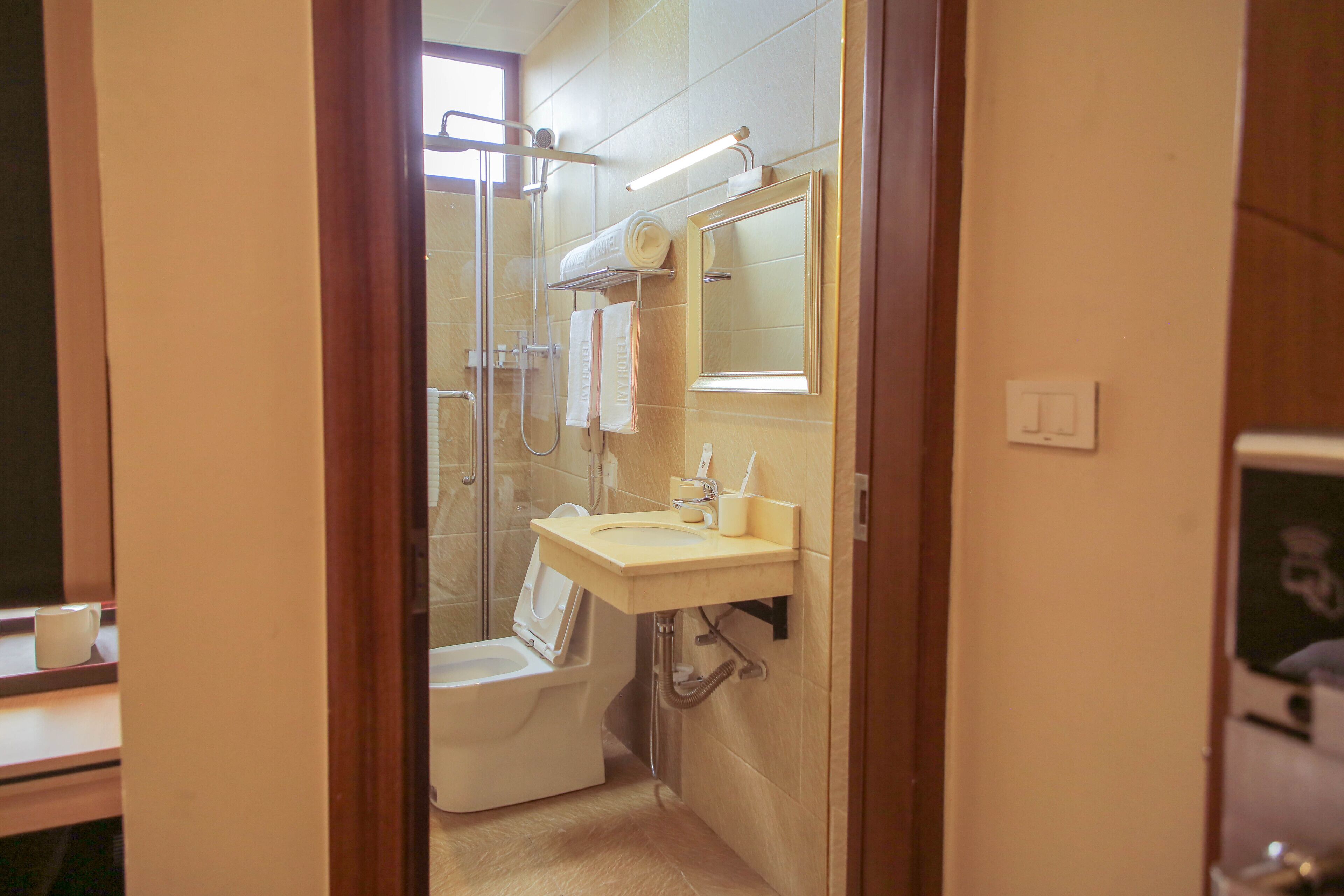 Une salle de bain équipée d’une douche, de toilettes, d’un lavabo et d’un miroir.