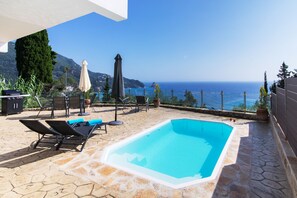 季節性室外游泳池，提供泳池遮陽傘和日光浴躺椅