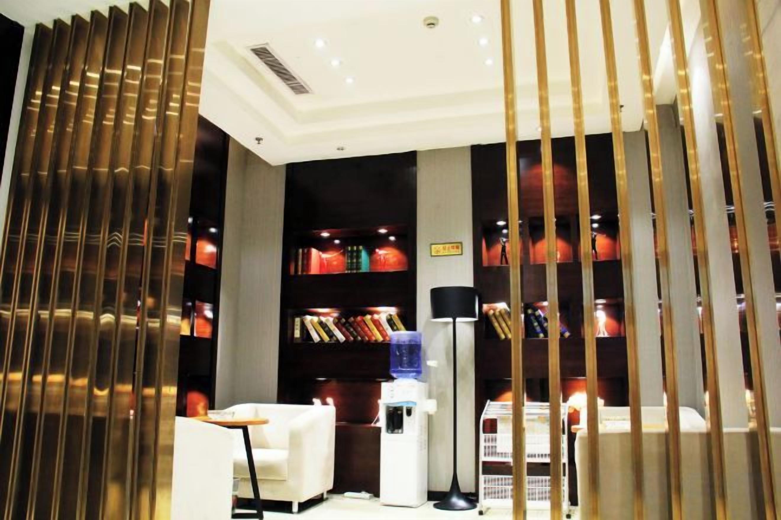 Habitación de hotel con diseño moderno, que incluye una estantería, un escritorio y una zona de estar.
