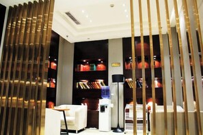 A hotel room with a modern design, featuring a bookshelf, a desk, and a seating area. - City Comfort Inn (Ziyun Getu Avenue) (Ziyun)