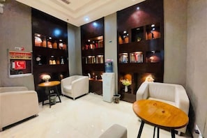 A hotel lobby with seating, a reception desk, and bookshelves. - City Comfort Inn (Ziyun Getu Avenue) (Ziyun)