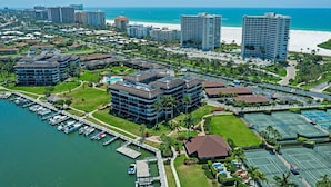 A coastal hotel with multiple buildings, a marina, and tennis courts. - Rare Garden Unit | Pool, Grills & Beach Access (Marco Island)