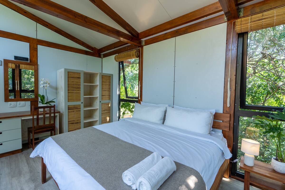 Ein Schlafzimmer mit einem Bett, einem Schreibtisch, einem Stuhl und einem Kleiderschrank.