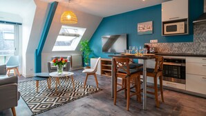 Una cocina moderna con comedor, que cuenta con un ventanal grande, un microondas y una mesa de comedor con sillas.