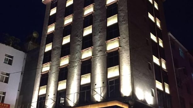 A multi-story building with illuminated windows and a visible balcony area. - Chuxiong Haiheng Hotel (Chuxiong City)