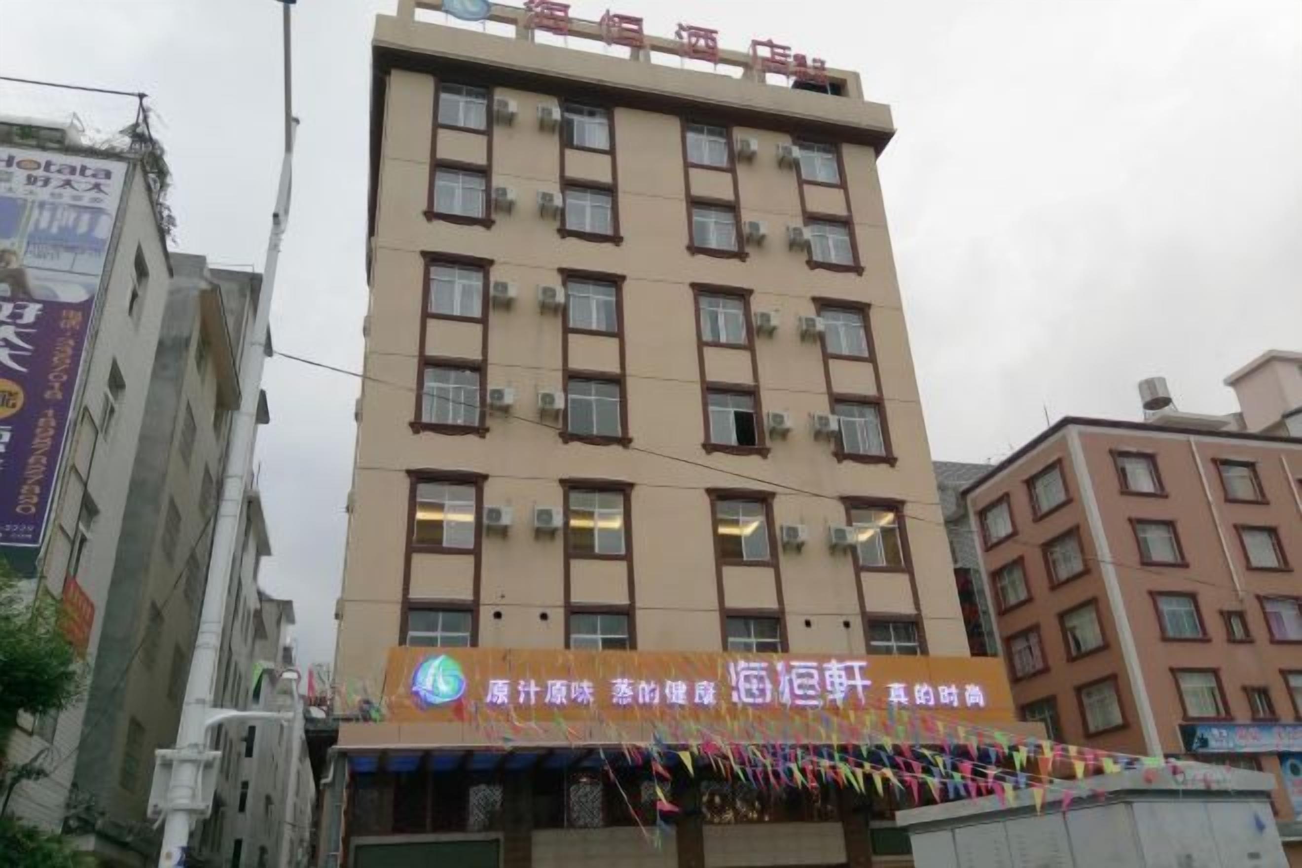 A multi-story building with a sign indicating it is a hotel.