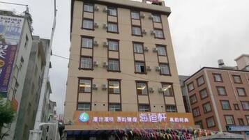 A multi-story building with a sign indicating it is a hotel.