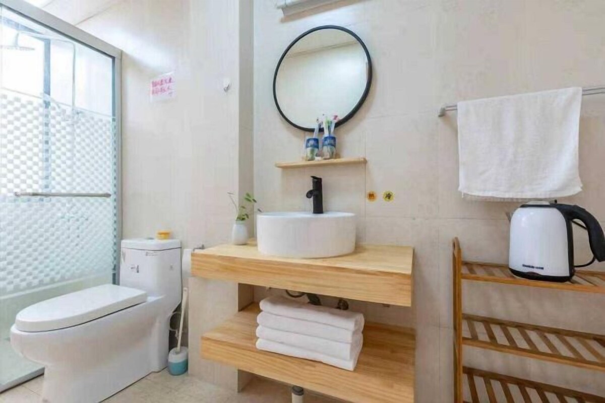 Et stilfuldt badeværelse med toilet, vask og bruseområde.