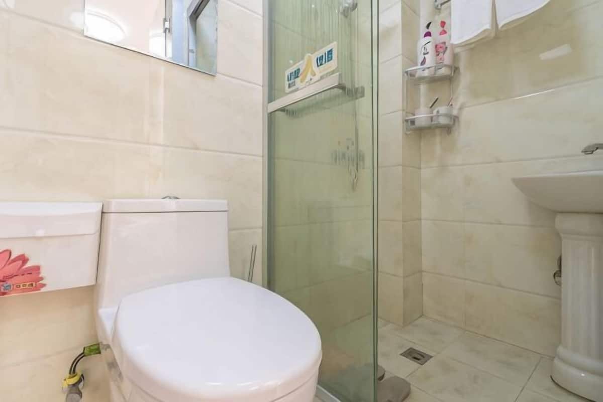 Un baño con inodoro, cabina de ducha de vidrio y lavabo.