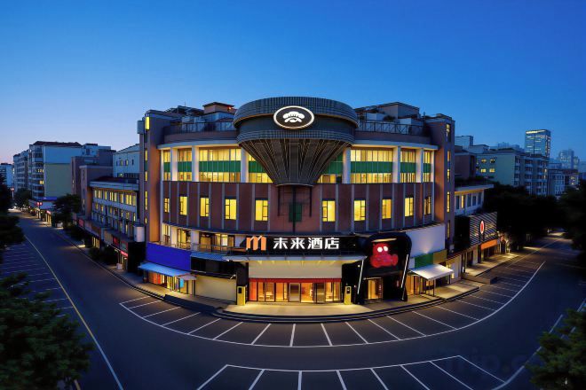 A hotel with a distinctive circular central feature, multiple floors, and a parking lot in front.