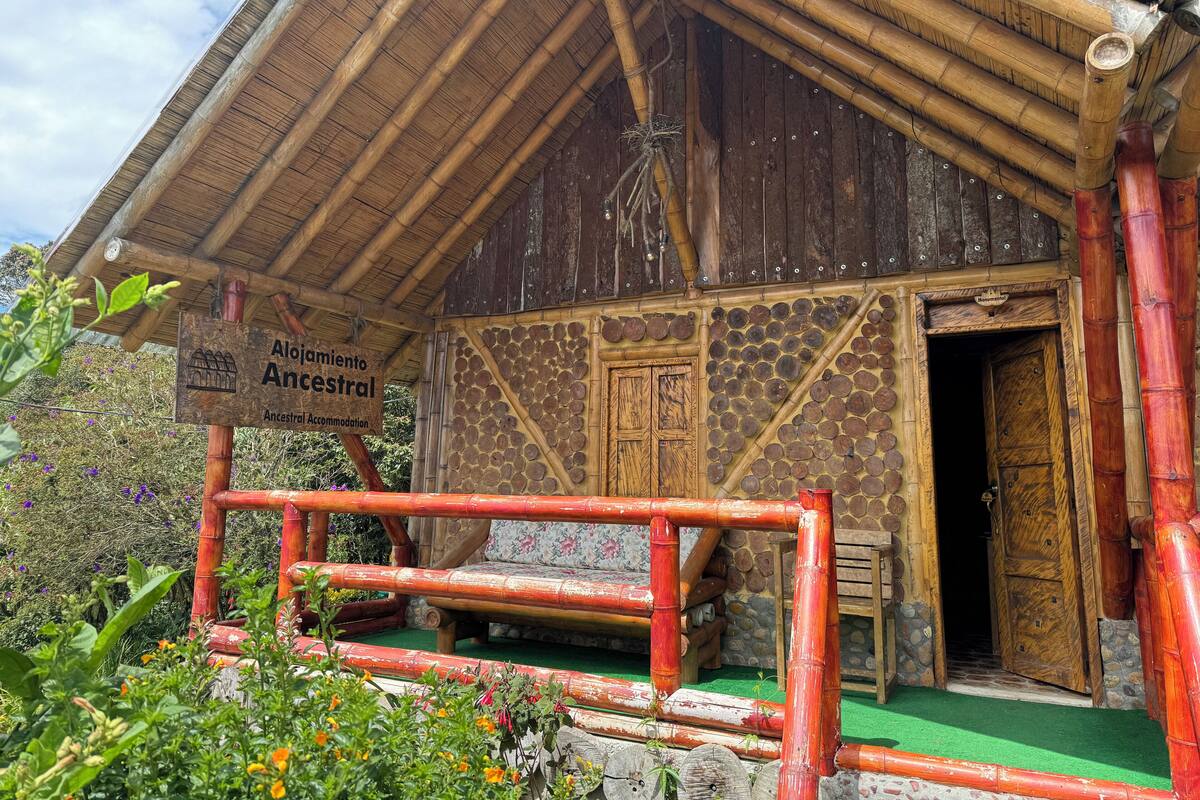 A rustic building with a bamboo roof and a sign reading "Ancestral Accommodation."