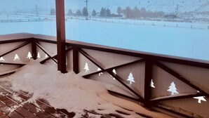Area esterna innevata con un pontile in legno e vista su un paesaggio innevato.