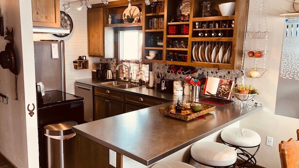 Una cucina moderna con isola centrale, elettrodomestici in acciaio inossidabile e mobili in legno.